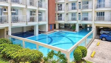 A multi-story hotel with a central swimming pool surrounded by balconies.