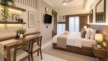 A modern hotel room with a bed, bedside tables, a desk, and chairs.