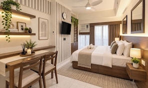A modern hotel room with a bed, bedside tables, a desk, and chairs. - Tagaytay Prime Residences In Tagaytay City (Tagaytay)