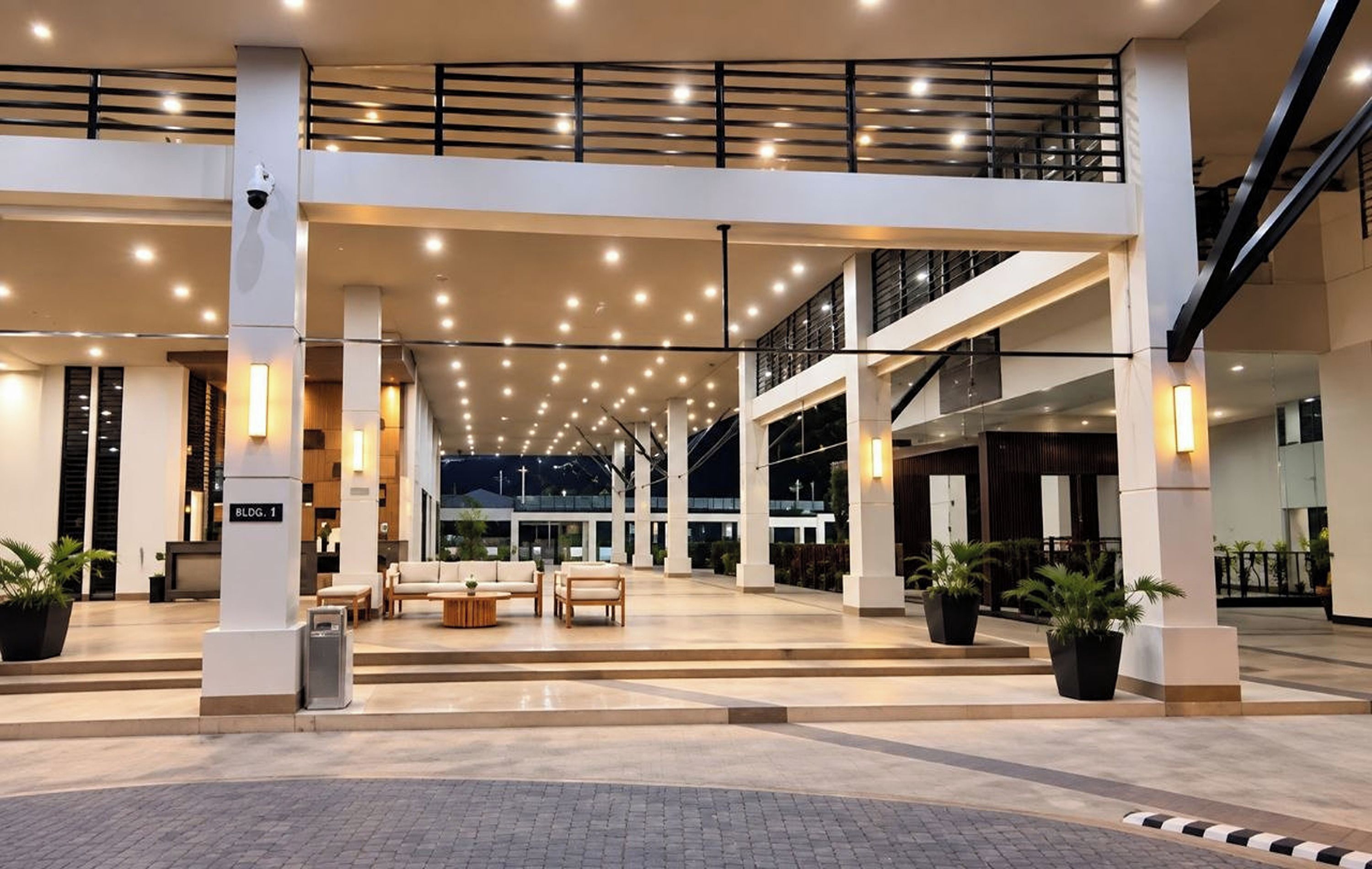 A spacious lobby with a high ceiling, multiple seating areas, and a staircase.