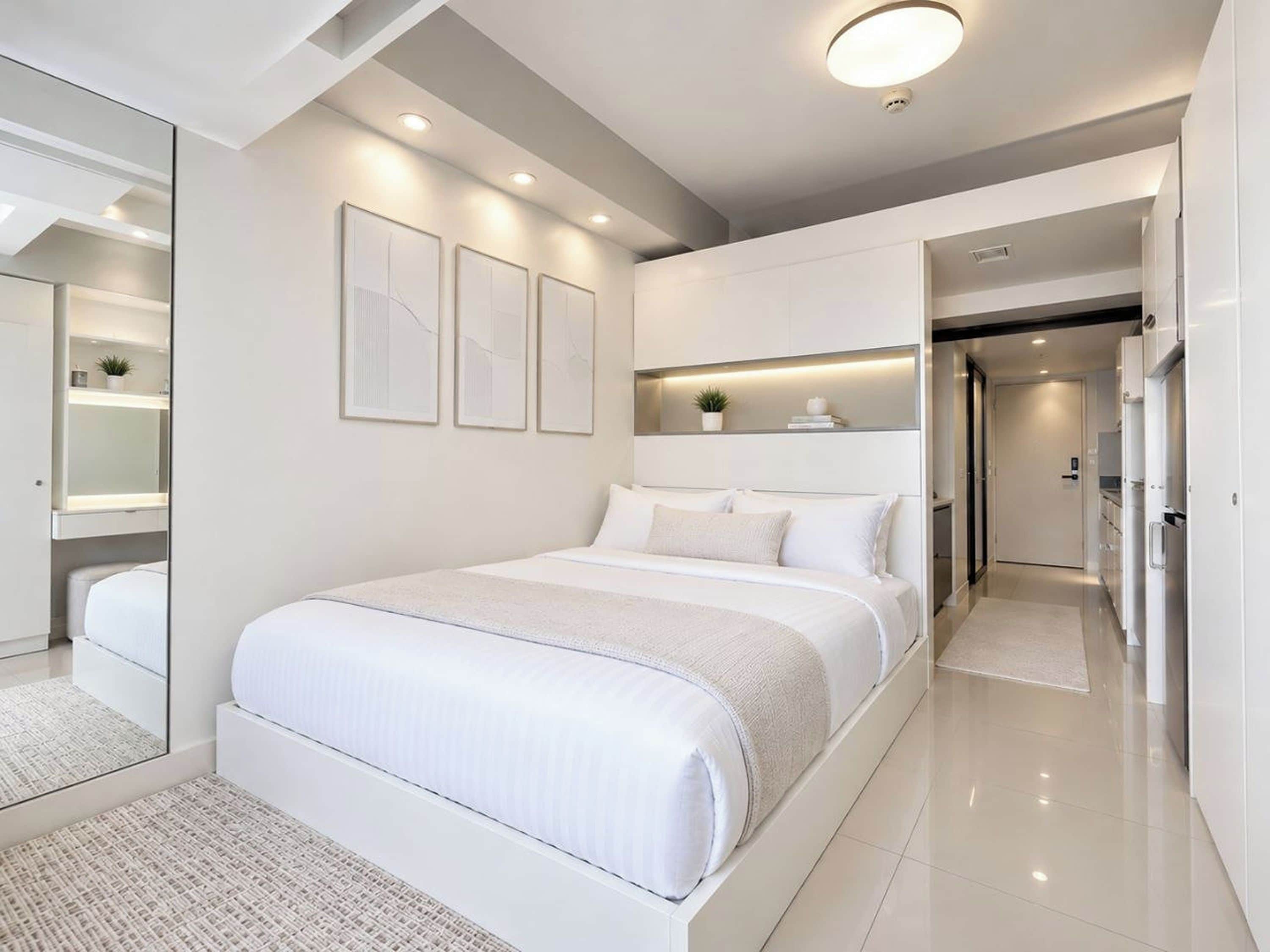 A modern bedroom with a large bed, built-in shelving, and a mirror.