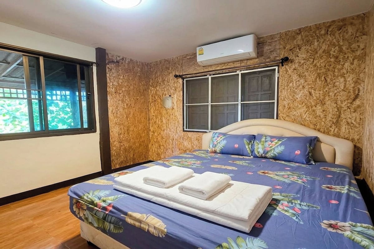 Un dormitorio con una cama, una ventana y un equipo de aire acondicionado.