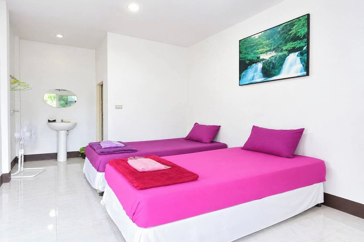 Una habitación de hotel con dos camas, un lavamanos y un espejo.