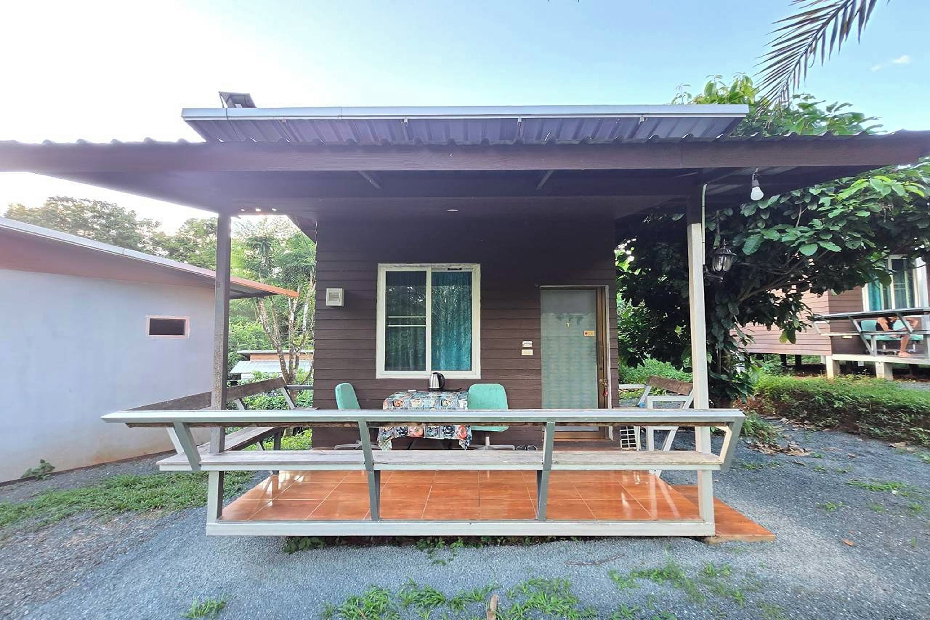 A small house with a porch, a table, and chairs.
