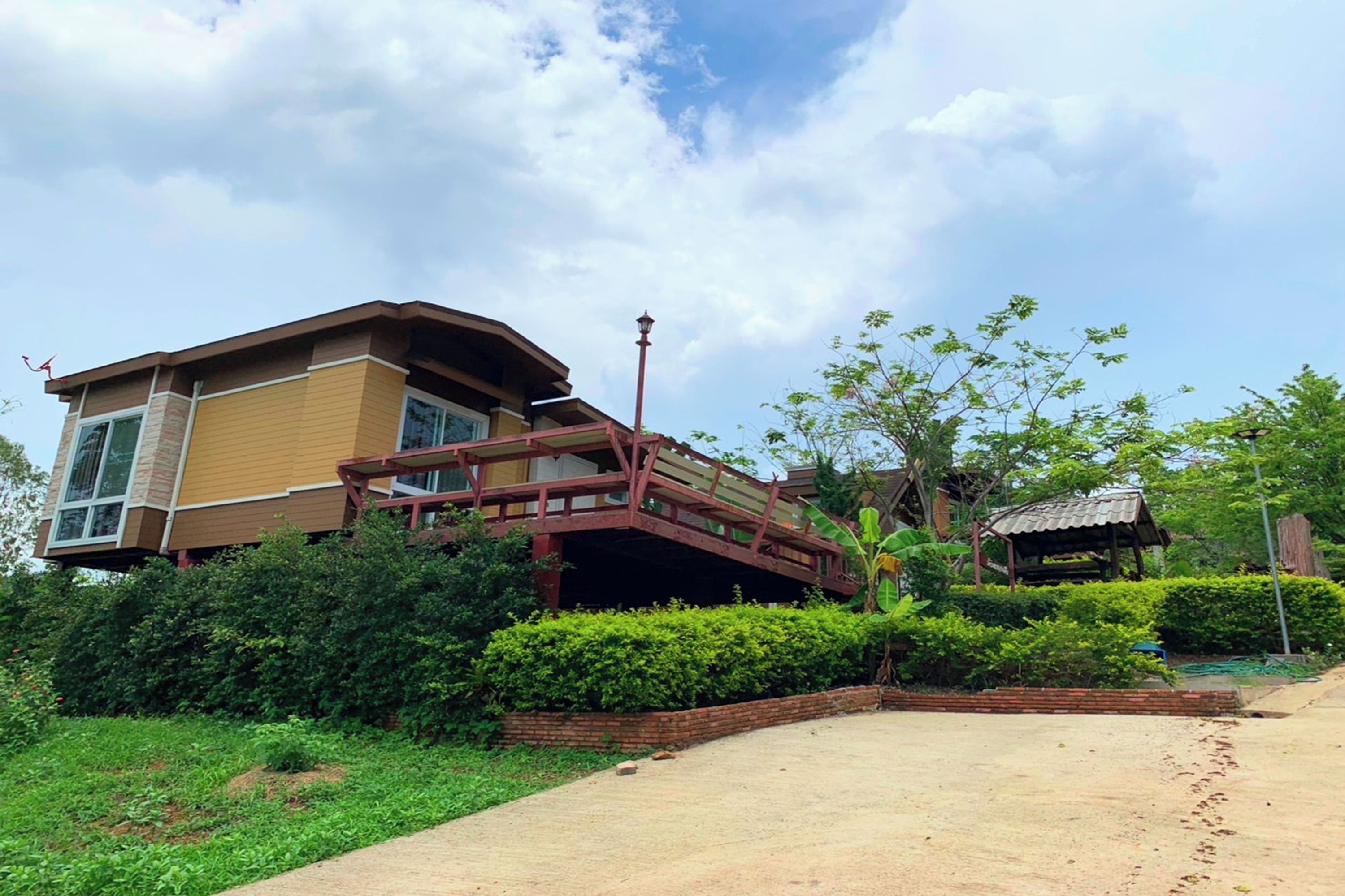A modern two-story house with a covered porch and a brick pathway leading to the entrance.