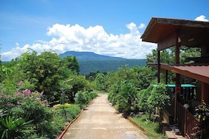 A pathway leading to a building with a view of a mountain range.