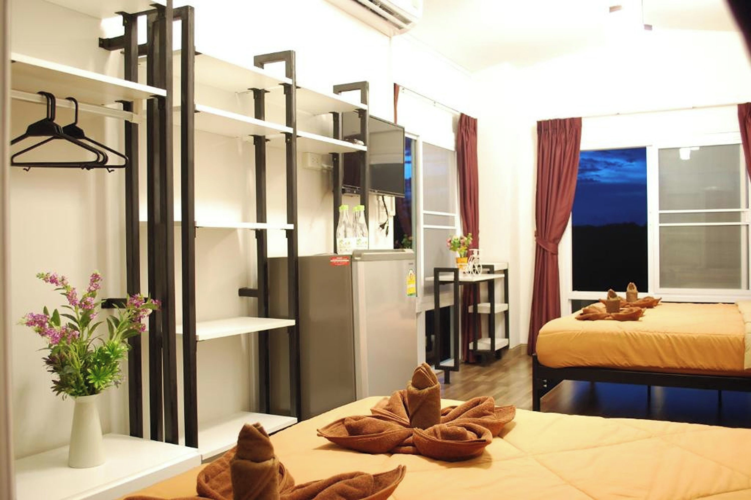 A hotel room with a bed, a desk, a wardrobe, and a hanging closet.