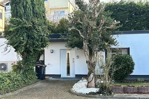 A residential building with a white facade, a black door, and a paved driveway. - Holiday home with 2 bedrooms (Lahnstein)