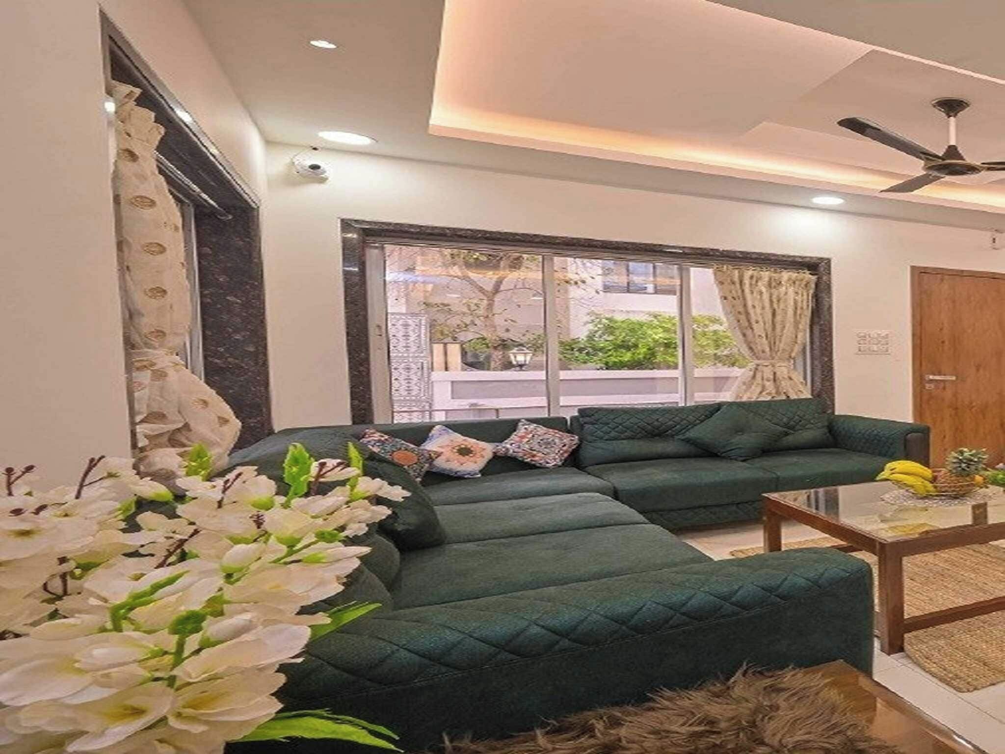 Una sala de estar moderna con un sofá seccional, una mesa de centro y un ventanal con cortinas.
