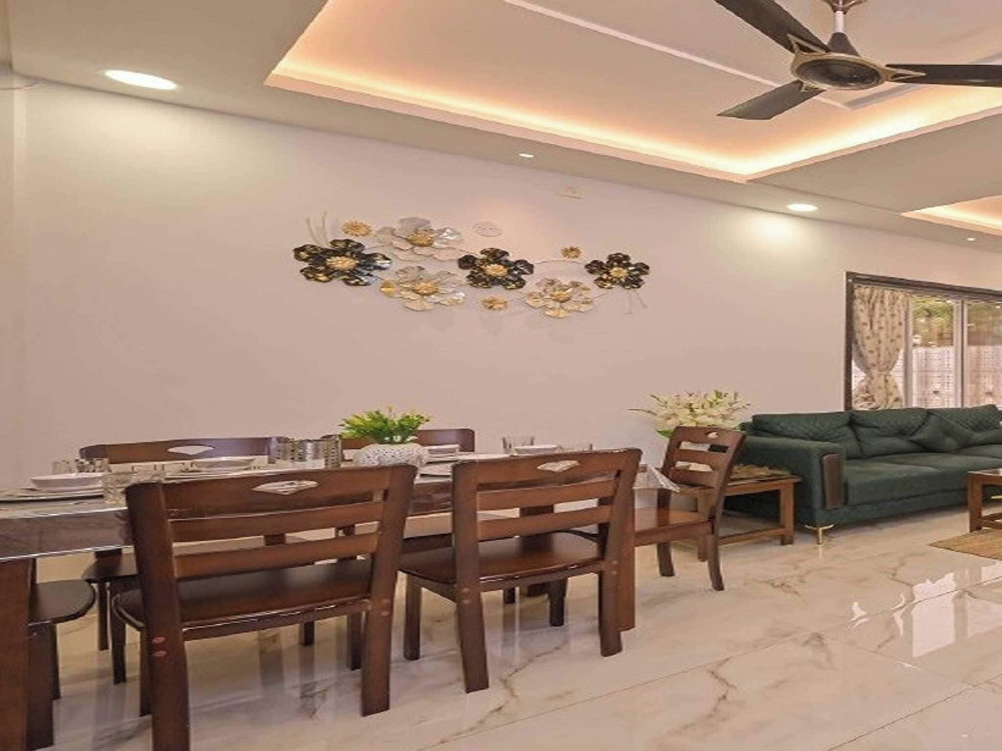 A dining area with a table and chairs, a ceiling fan, and a wall-mounted decorative piece.