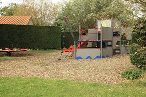 A playground with a slide and climbing structures. - Holiday apartment with 3 bedrooms (Zoutelande)