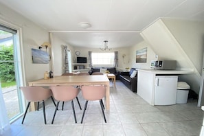 A modern kitchen with a dining area, a refrigerator, and a microwave. - Holiday apartment with 3 bedrooms (Zoutelande)
