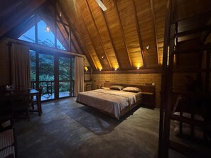 Una camera da letto con un letto grande, un soffitto in legno e vista attraverso una porta vetrata.