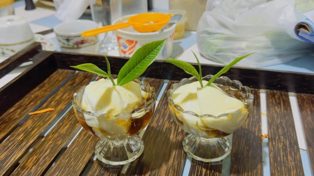 Two dessert bowls on a tray with a wooden surface.