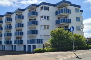 A multi-story residential building with balconies, a pedestrian crossing sign, and a clear sky. - House Poseidon Apartment 8 Hempel (Cuxhaven - Duhnen)