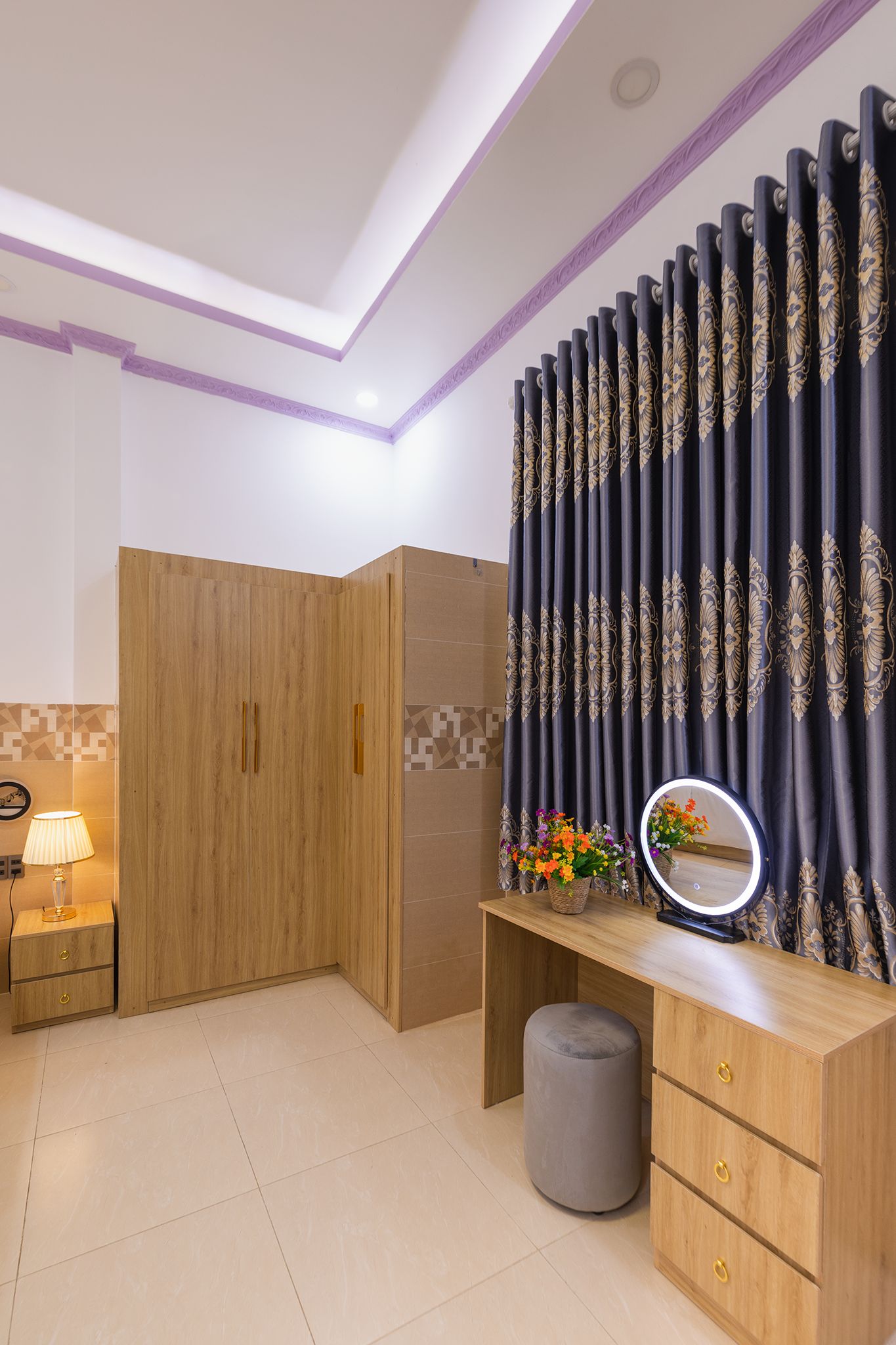 A bathroom with a wooden vanity, a mirror, and a decorative curtain.