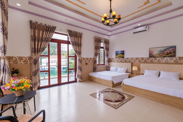 A hotel room with two beds, a dining area, and a view of the outdoors. - Sunlit Seaside Villa Phú Quốc (Phú Quốc)