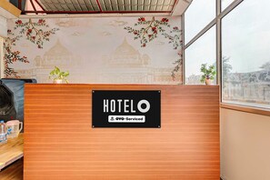 Taulell de recepció d'hotel amb un senyal que indica que ofereix serveis OYO.