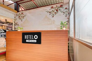 Een hotel receptie met een bordje dat aangeeft dat het een OYO-service is.