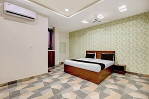 Ein Schlafzimmer mit einem Bett, einem Nachttisch, einer Klimaanlage und einer Wand mit Muster.