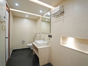 Un baño con inodoro, lavamanos y toallero.