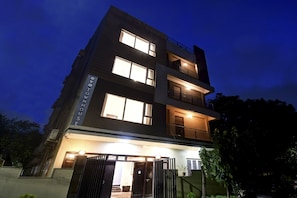 A multi-story building with illuminated windows and a gated entrance. - Super Townhouse All In One (Kolkata)