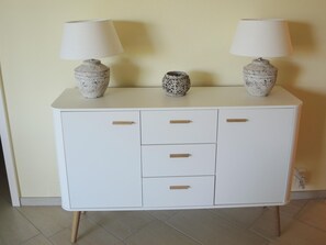 A white cabinet with three drawers and two lamps on top. - La Palma by Interhome (Brissago)