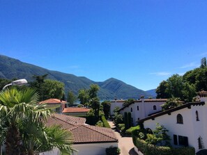 A residential area with white buildings, red-tiled roofs, and lush greenery. - Residenza Lido Golf by Interhome (Ascona)