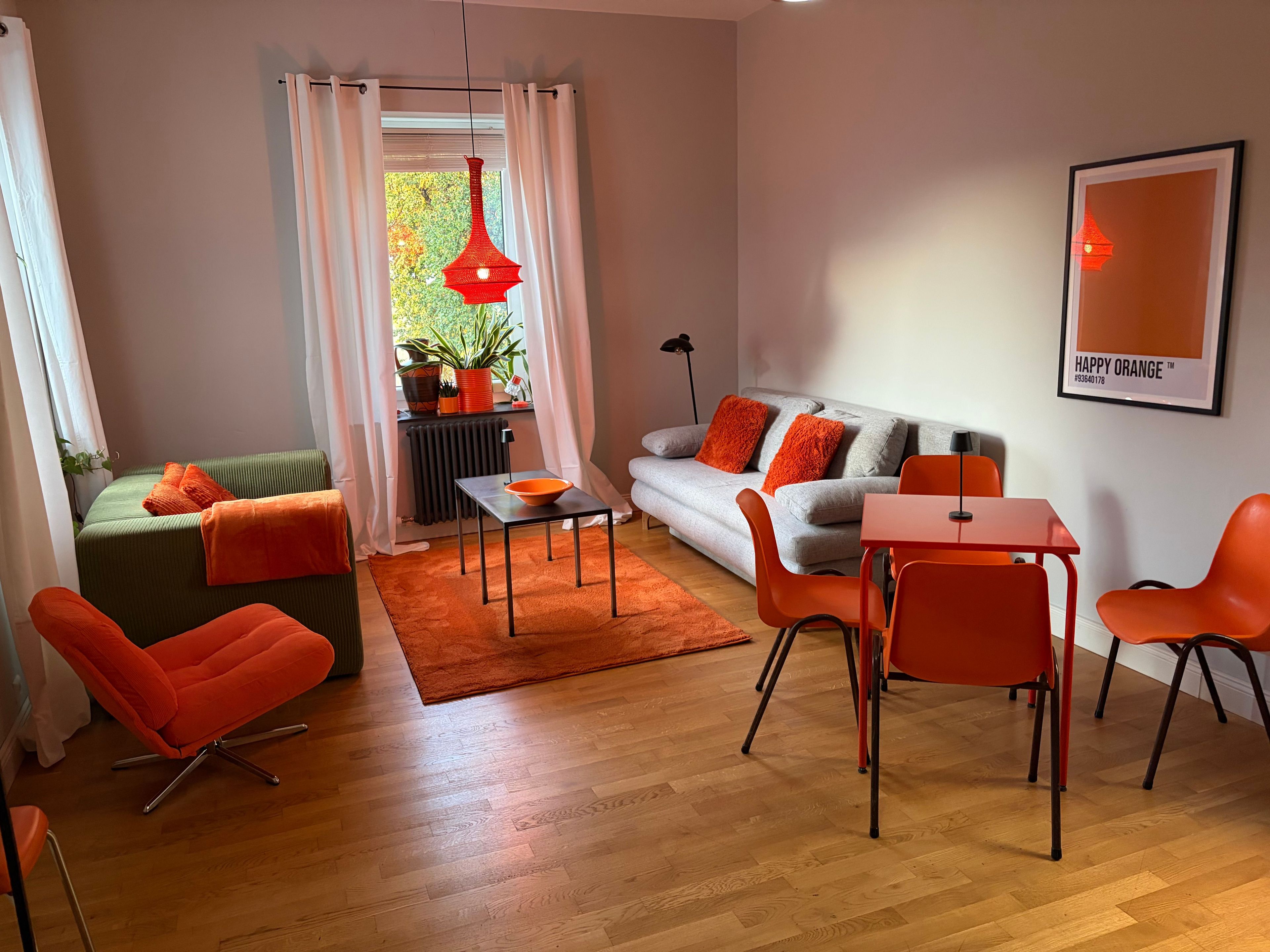 Ein modernes Wohnzimmer mit einer Couch, Sesseln, einem Tisch und einer Heizung.
