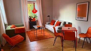 Ein modernes Wohnzimmer mit einer Couch, Sesseln, einem Tisch und einer Heizung.