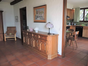 A spacious kitchen with a wooden island, a dining area with chairs, and a painting on the wall. - Casa Miriam by Interhome (Gordola)
