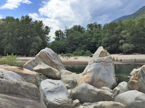 A natural landscape with large rocks and a river, surrounded by trees and a mountain in the background. - Casa Gialla by Interhome (Locarno Tegna)