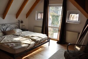 A bedroom with a bed, a chair, and a window. - ||-------------------in "Haus Erika"-------------------|| (Langenargen)