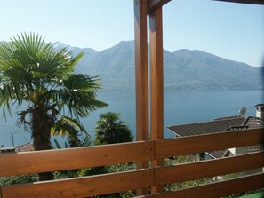 A wooden balcony overlooking a lake with mountains in the background. - Piccolo Mondo 1 by Interhome (Minusio)