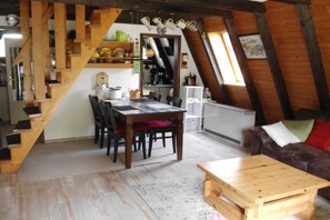 Un espace de vie de style loft comprenant un coin repas, un escalier et une cuisine.