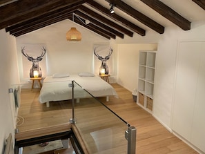 A bedroom with a bed, two wall-mounted lamps, and a wooden ceiling. - Il Nido by Interhome (Ronco sopra Ascona)