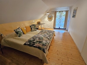 A bedroom with a bed, a small table, and a window with curtains. - Rustico La Rocca by Interhome (Aurigeno)