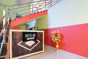 Una recepción de hotel con un cartel que indica servicio de empresa.