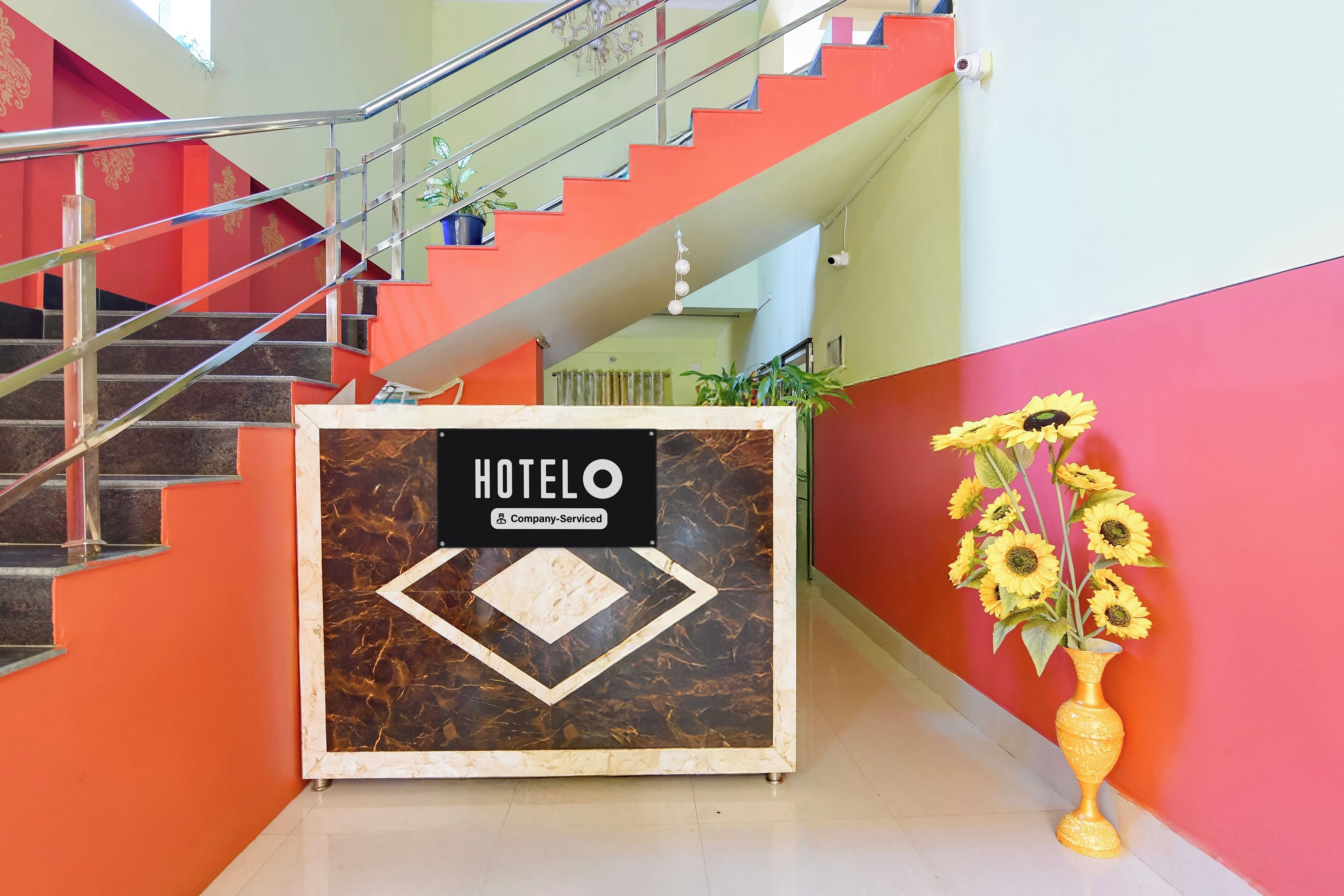 A hotel reception desk with a sign that reads 'HOTELO Company-Serviced.'