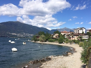 A coastal town with a rocky shoreline, boats, and buildings with a mountainous backdrop. - Casa Andrea Chefétage by Interhome (Gerra)