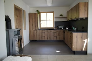 Eine Küche mit Holzausstattung, einem Fenster und einer Arbeitsfläche mit Geräten.