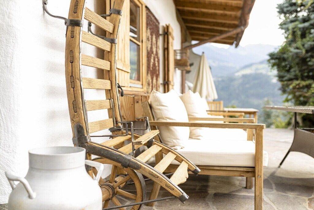 Un espacio de estar al aire libre con madera y vistas a las montañas.