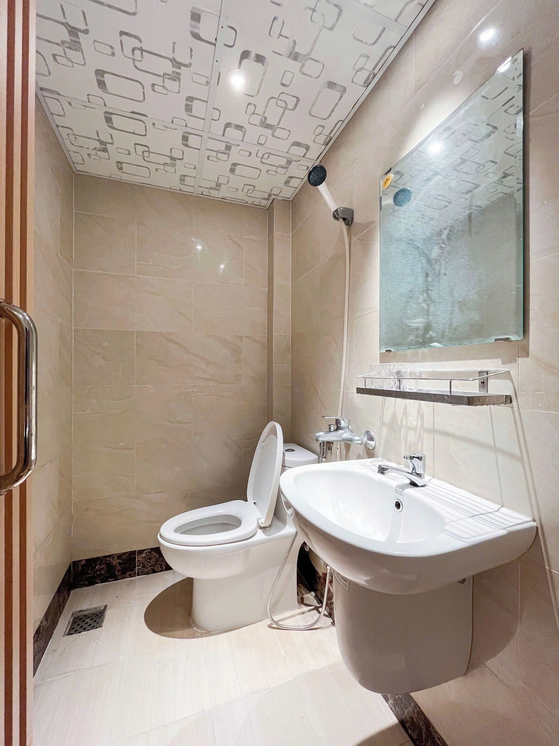 Een moderne badkamer met toilet, wastafel en douche.