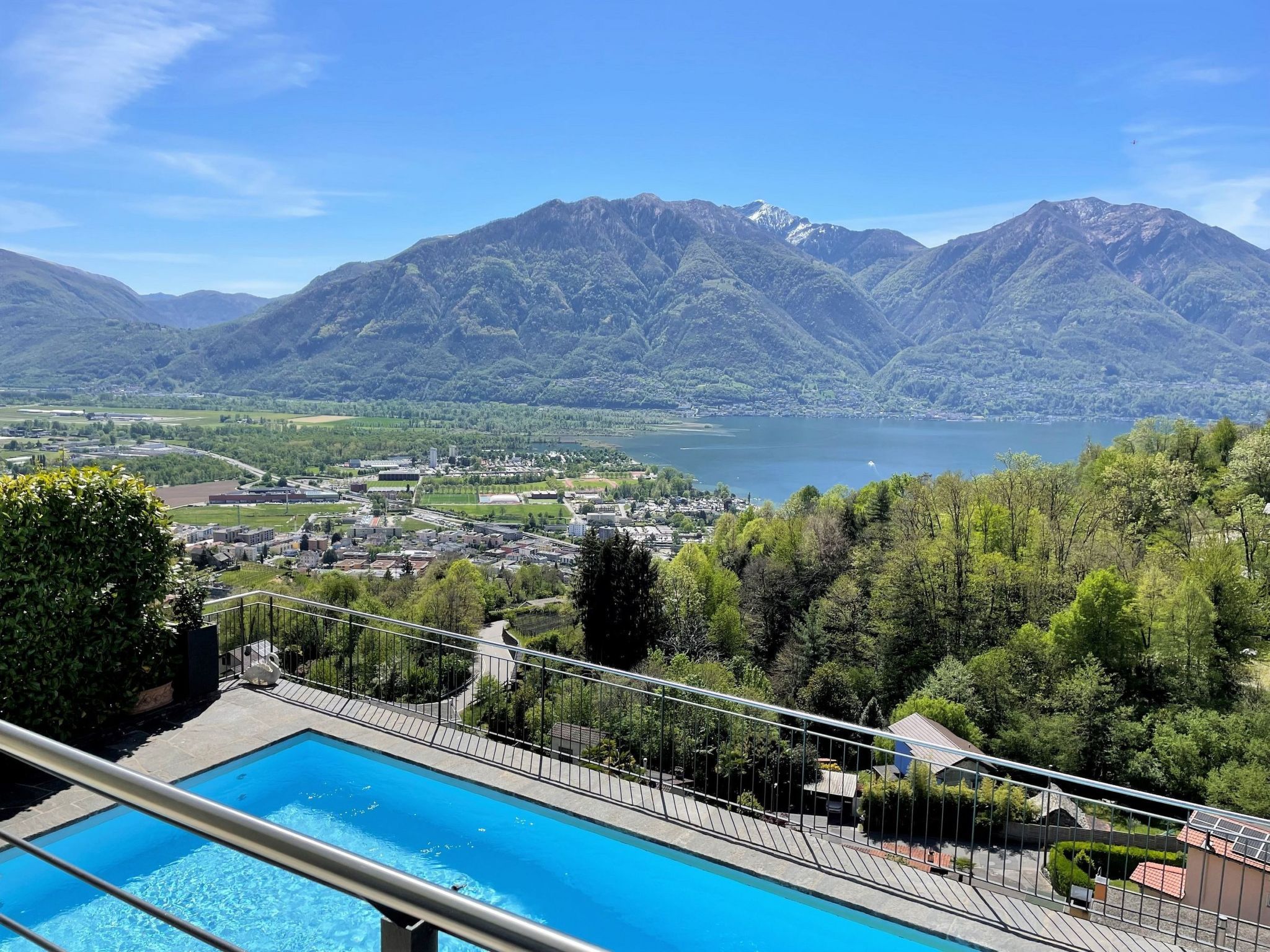 A swimming pool with a view of a lake and mountains.