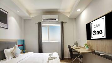 A hotel room with a bed, a desk, a chair, an air conditioning unit, a window with curtains, and a TV screen displaying 'Cyber One'.