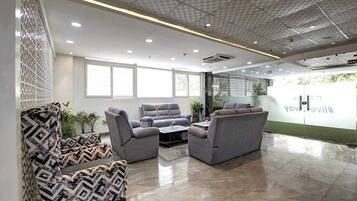 A modern waiting area with sofas, a coffee table, and a patterned chair.