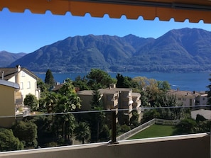 A residential area with buildings, a balcony, and a mountain backdrop. - Bellavista by Interhome (Locarno)