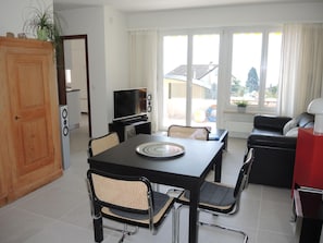 A modern living room with a dining table, chairs, a television, and a sofa. - Bellavista by Interhome (Locarno)