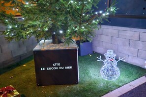 A Christmas tree with lights, a snowman decoration, and a sign that reads 'GÎTE LE COCON DU RIED'. - ||---------------------------Le cocon du Ried----------------------|| (Mussig)