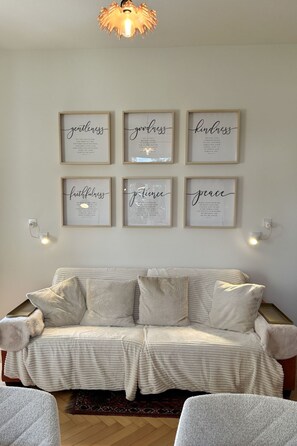 A living room with a sofa and six framed inspirational quotes on the wall. - Villa Clara by Interhome (Minusio)
